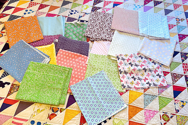 assorted fabric on quilted bed