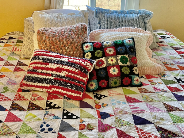 crochet pillows on quilted bed