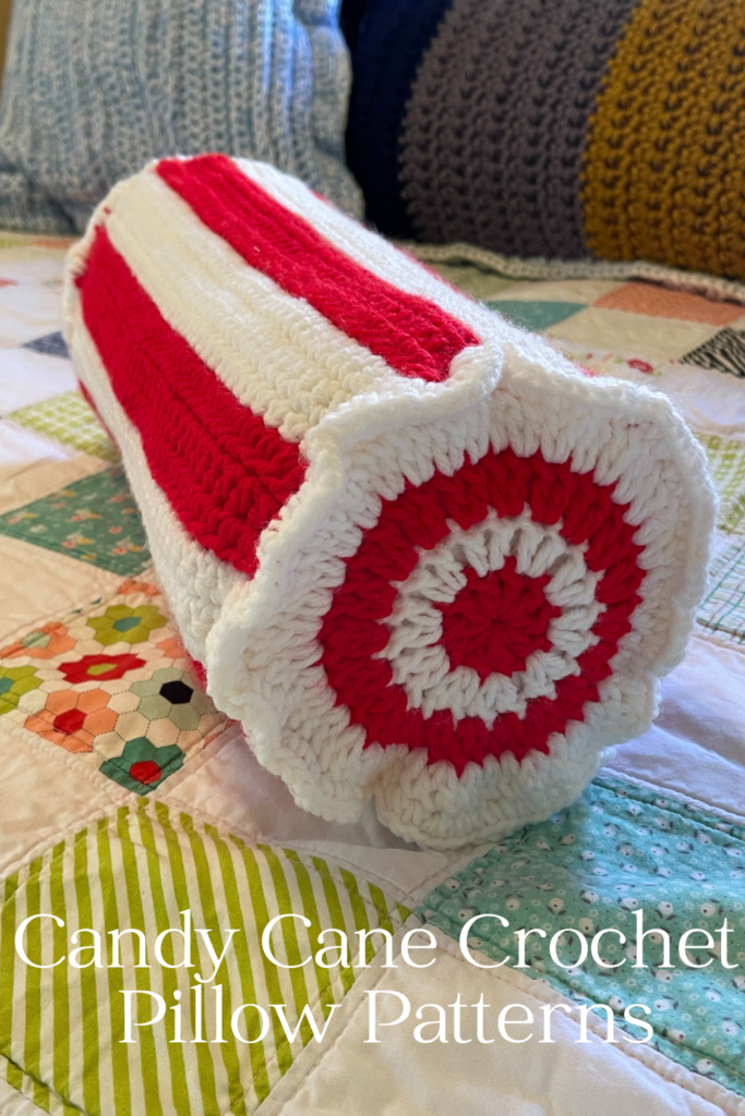 crocheted neck roll pillow laying on quilted bed