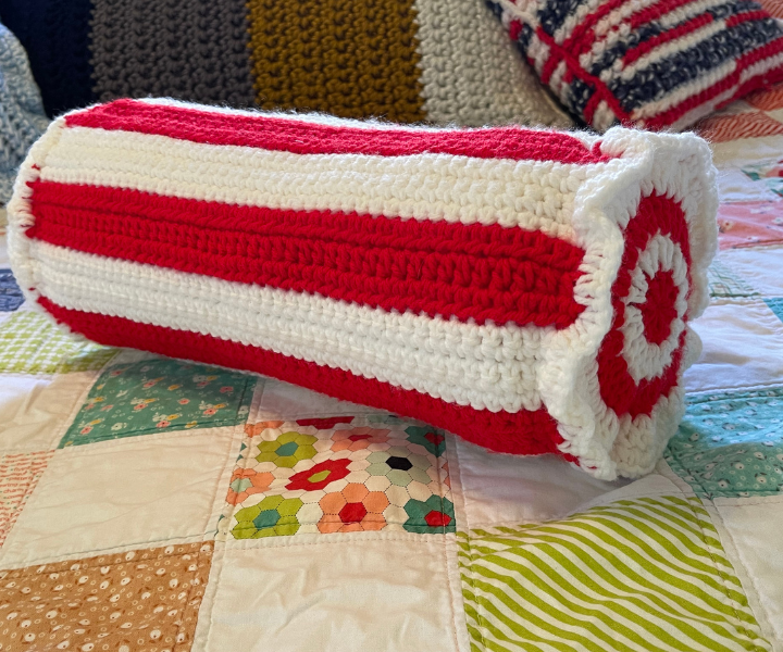 crochet neck roll pillow on quilt