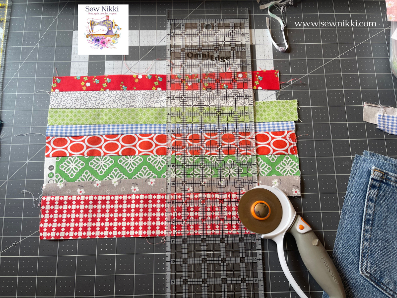 cutting fabric with quilt ruler and rotary cutter on matt