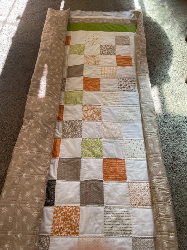 rolled up quilt top on floor