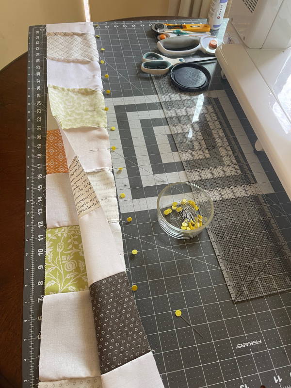 pinning quilt rows on sewing table