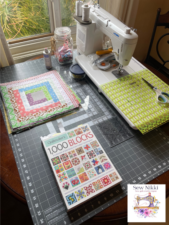 finished quilt blocks and sewing items on cutting matt
