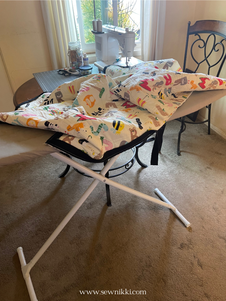 using ironing board to keep quilt off of floor dragging