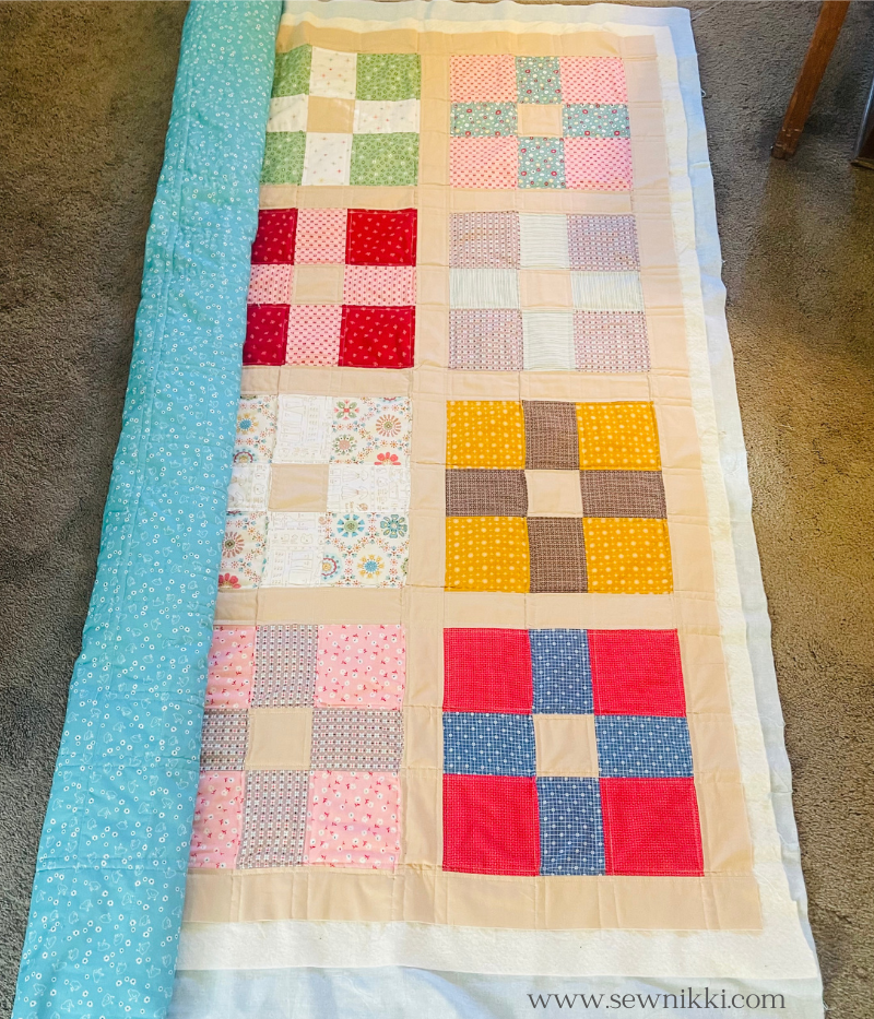 rolling quilt out on floor to prepare it for quilting in opposite direction on sewing machine