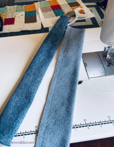 denim handle strips waiting to be sewn on sewing machine