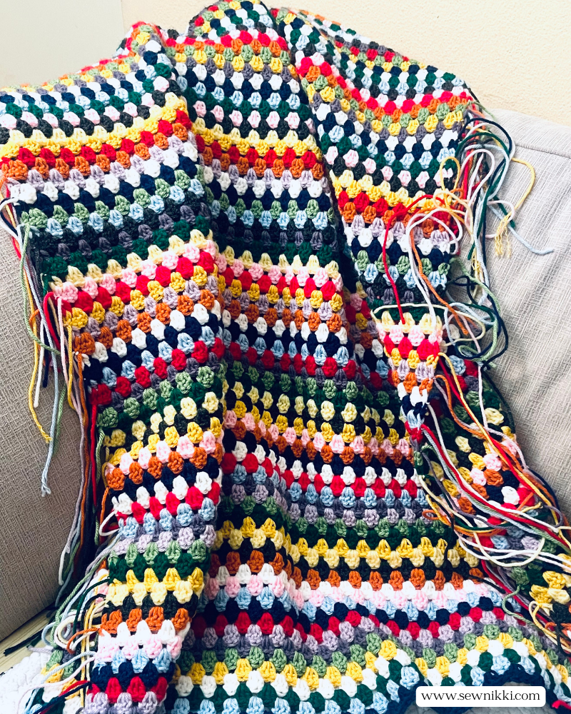 Easy Granny Stitch Crochet Blanket by Sew Nikki - Measuring my baby blanket in progress with all those tails!