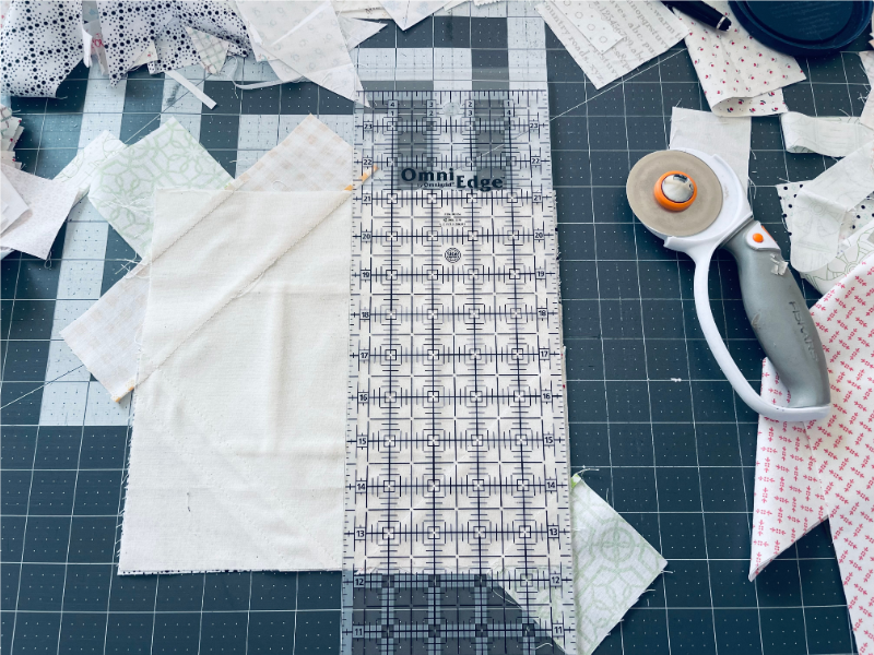 Flip your block over and use the muslin piece as a cutting guide, trim excess fabric from scrap pieces off by Sew Nikki.