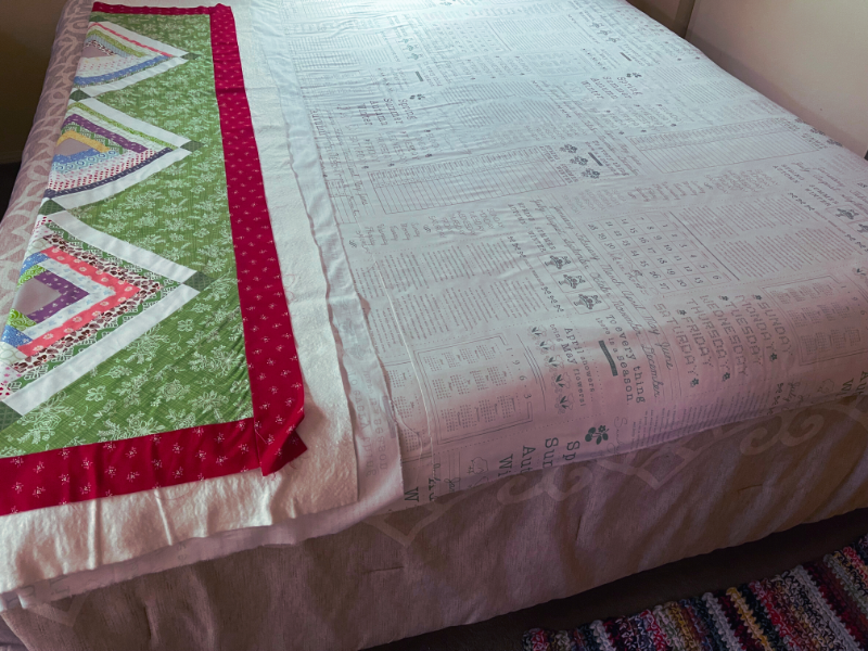 How to baste a quilt - finished spray basting, smoothing out wrinkles with hands until satisfied by Sew Nikki.