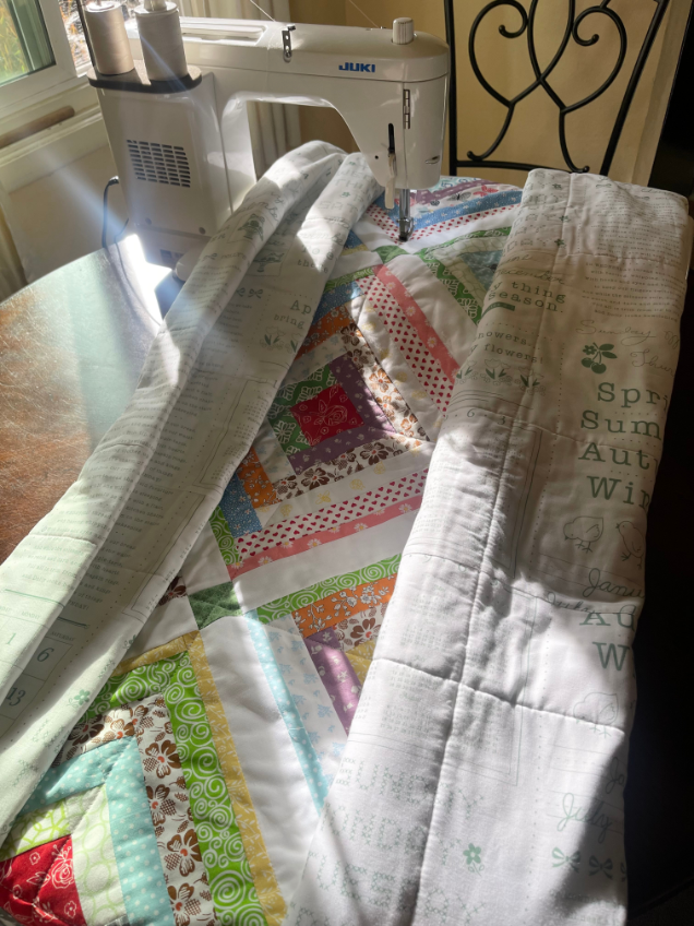 How to quilt on a regular sewing machine - roll the sides of the quilt so it will fit under the throat of machine.
