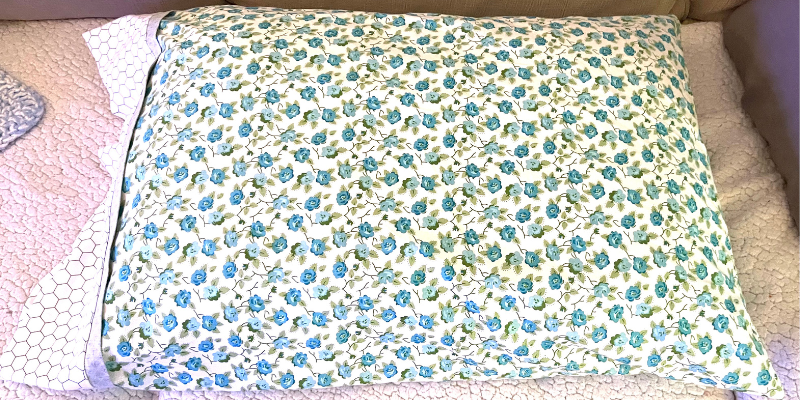 Finished pillowcase with flap sitting on sofa by Sew Nikki
