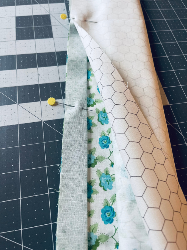 Fold the flap fabric over the piping fabric and pin in place by Sew Nikki.