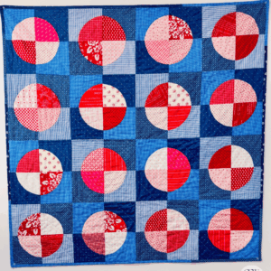 Finished Circle Baby Quilt hanging on my office wall by Sew Nikki