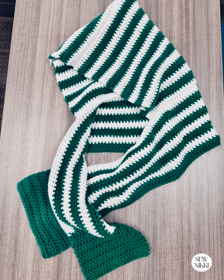 The Hoodie Scarf laying on desk, half double crochet pattern by Sew Nikki