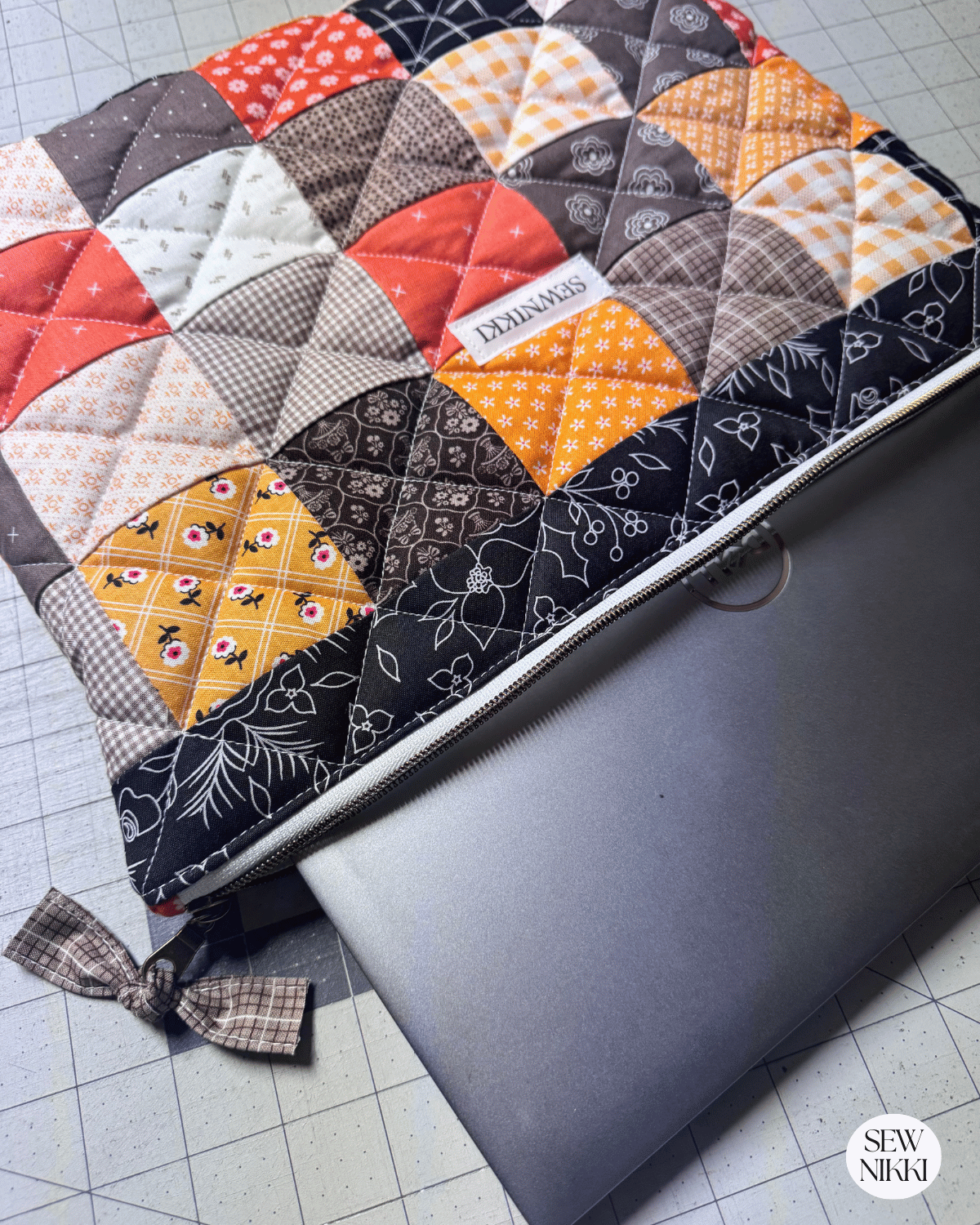 Finished quilted laptop sleeve sewing pattern by Sew Nikki with computer in it.