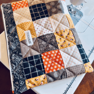 Finished quilted zippered laptop case sitting on my sewing table by Sew Nikki
