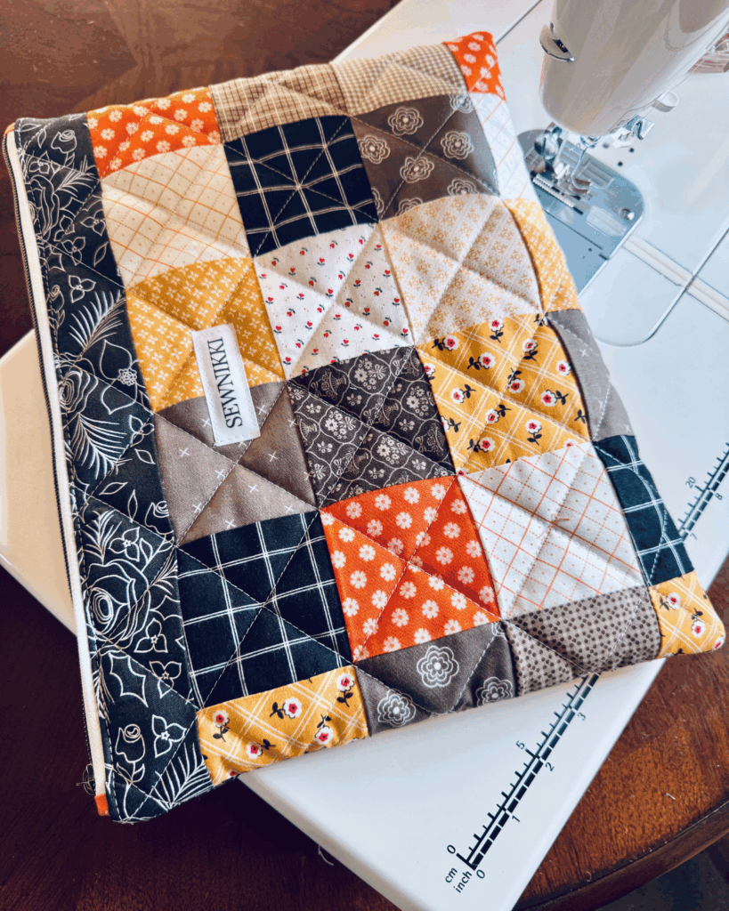 Finished quilted zippered laptop case sitting on my sewing table by Sew Nikki