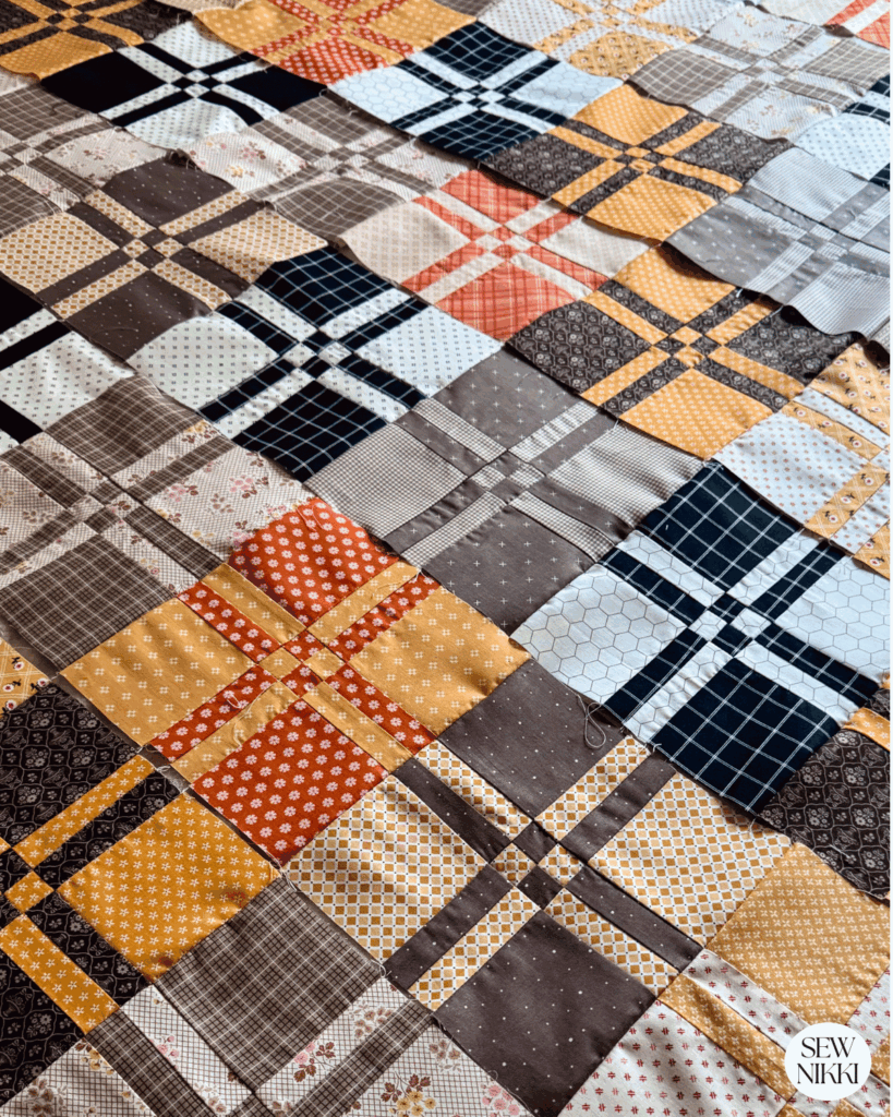 Bella disappearing four patch quilt pattern finished rows laying on bed by Sew Nikki