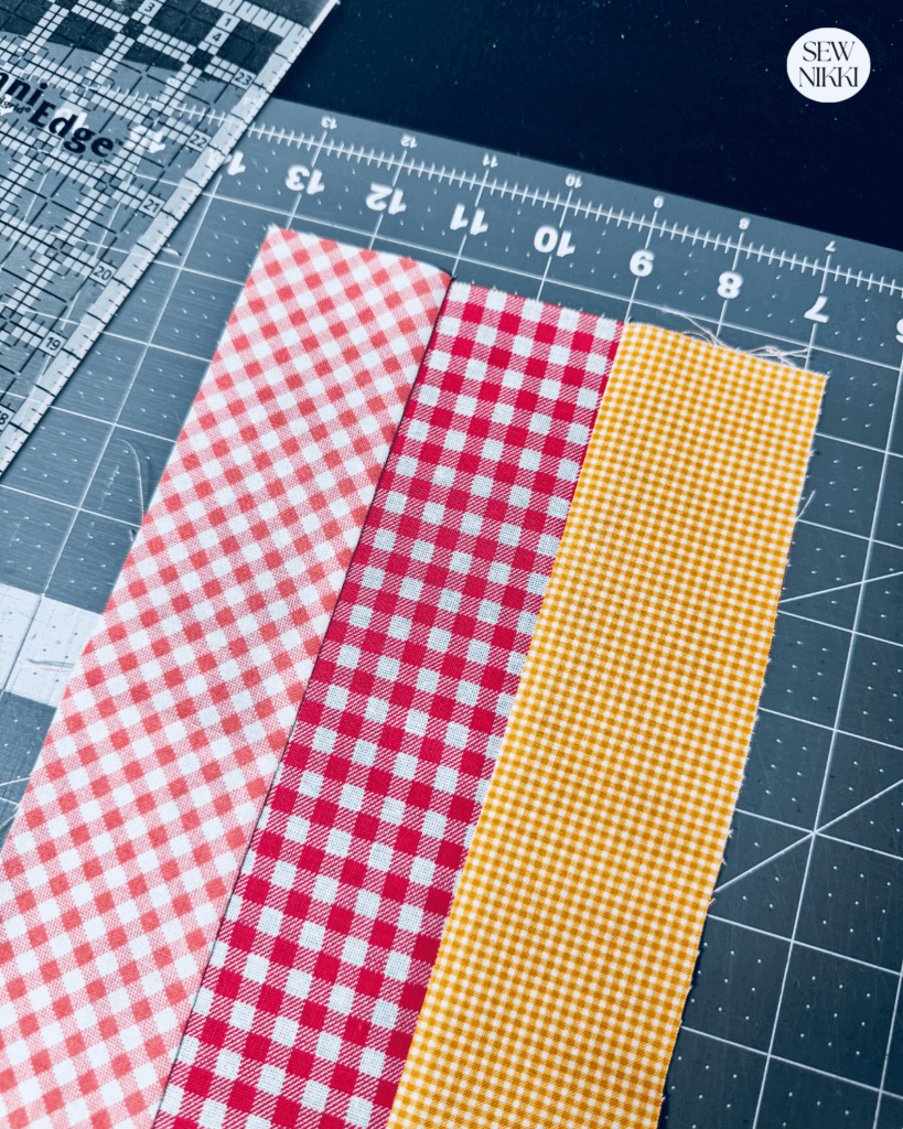 Trimming the strip sets using the cutting matt grid lines by Sew Nikki