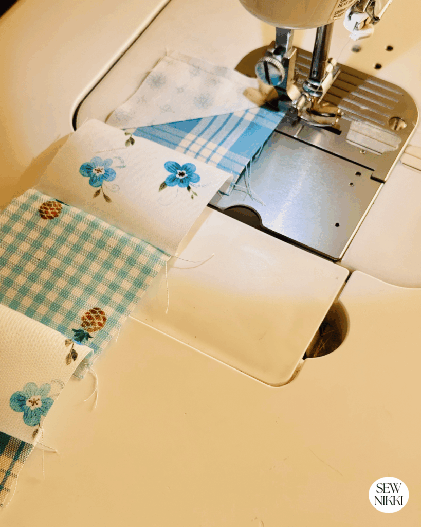 Attaching the setting triangles to the start and end of each row, going slowly on the bias fabric by Sew Nikki