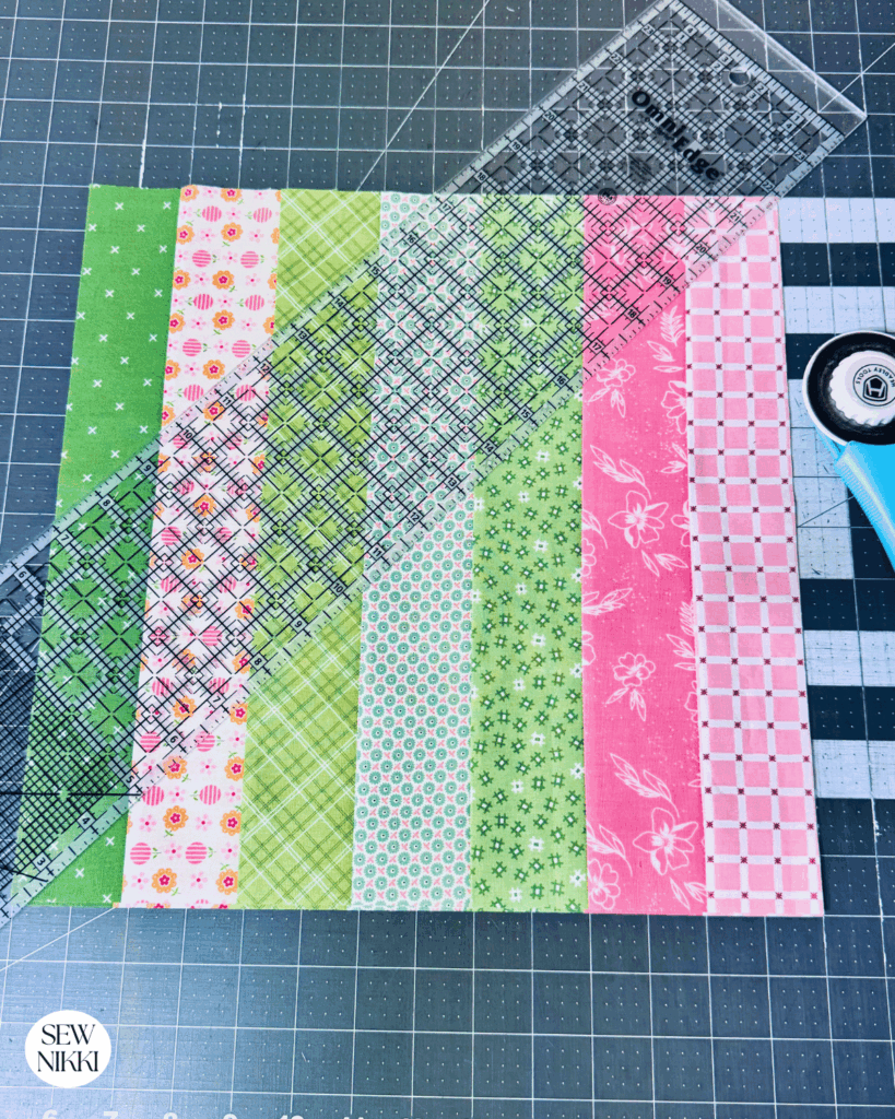 Cut the strip blocks in half diagonally for the Ohio Star quilt pattern by Sew Nikki