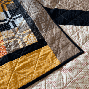 Quilt Binding Tips and Tricks for Intermediate Quilters - finished quilt with binding on home sewing machine by Sew Nikki