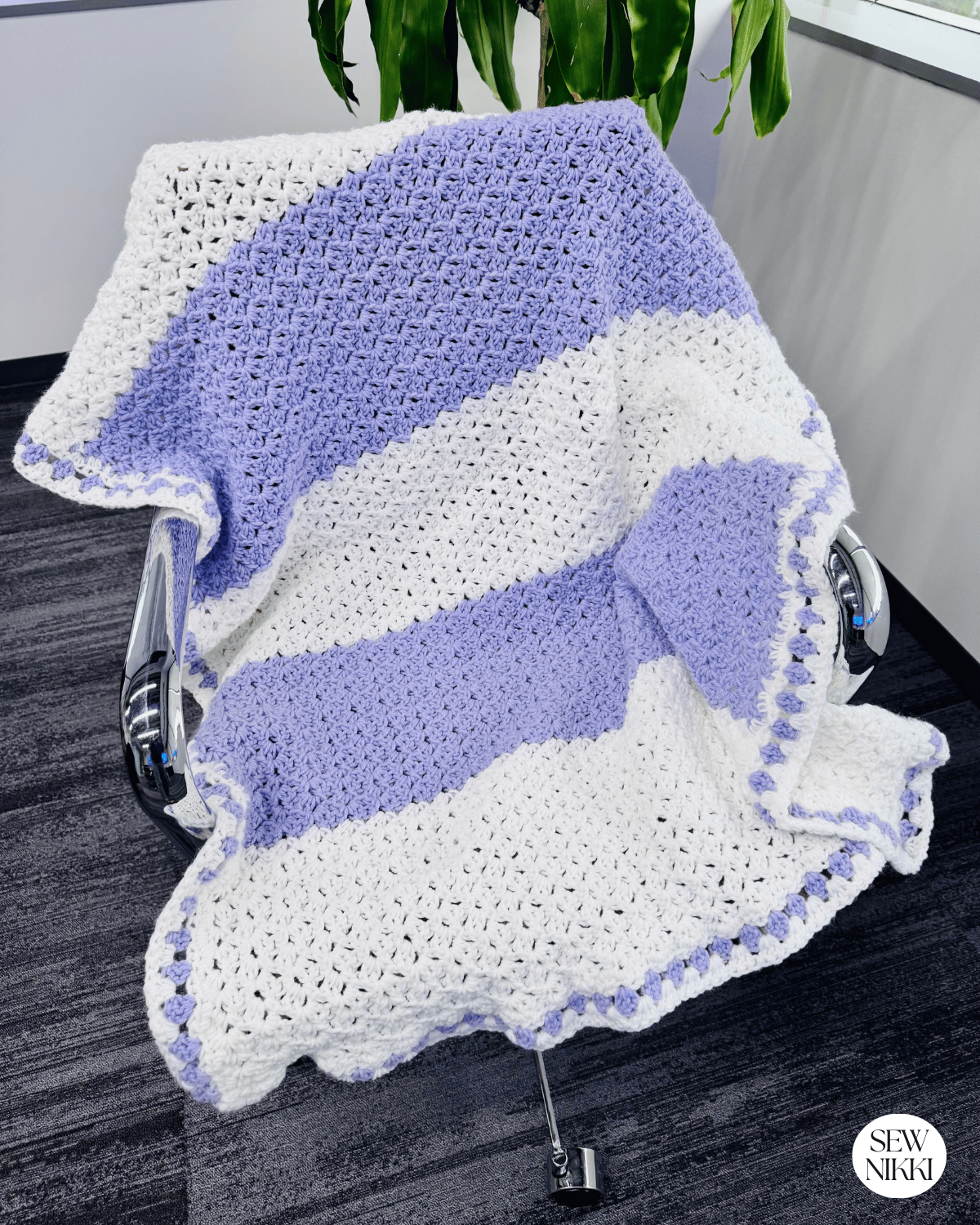 Reverse blanket stitch crochet lap blanket free crochet pattern by Sew Nikki - finished blanket hanging over chair.