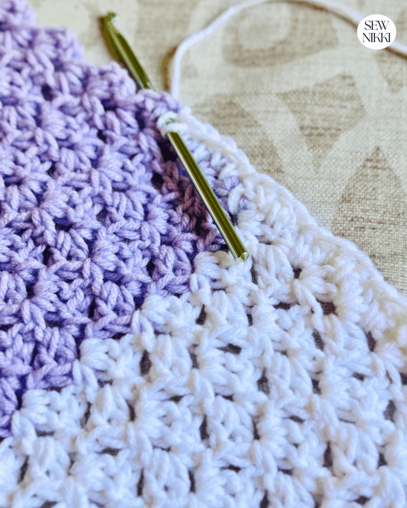 Working the first border round on this free crochet blanket pattern by Sew Nikki