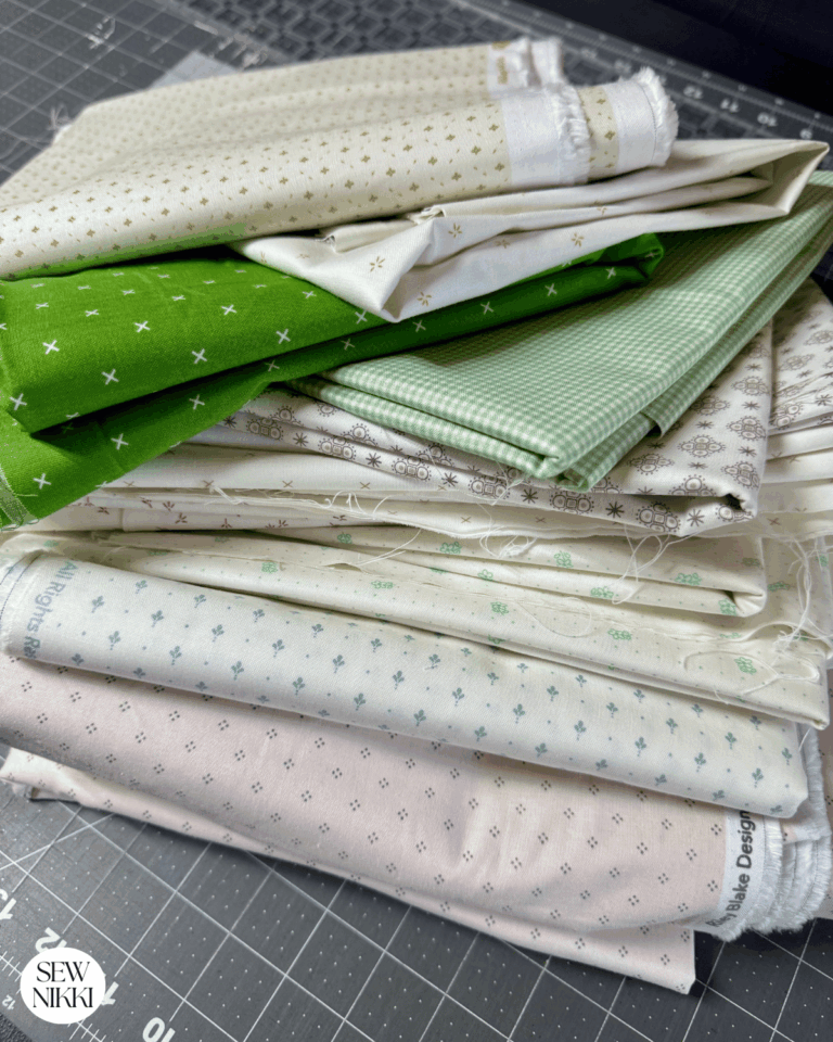 How Many Yards of Fabric Do You Need for a Quilt by Sew Nikki - a stack of fabric by the yard.