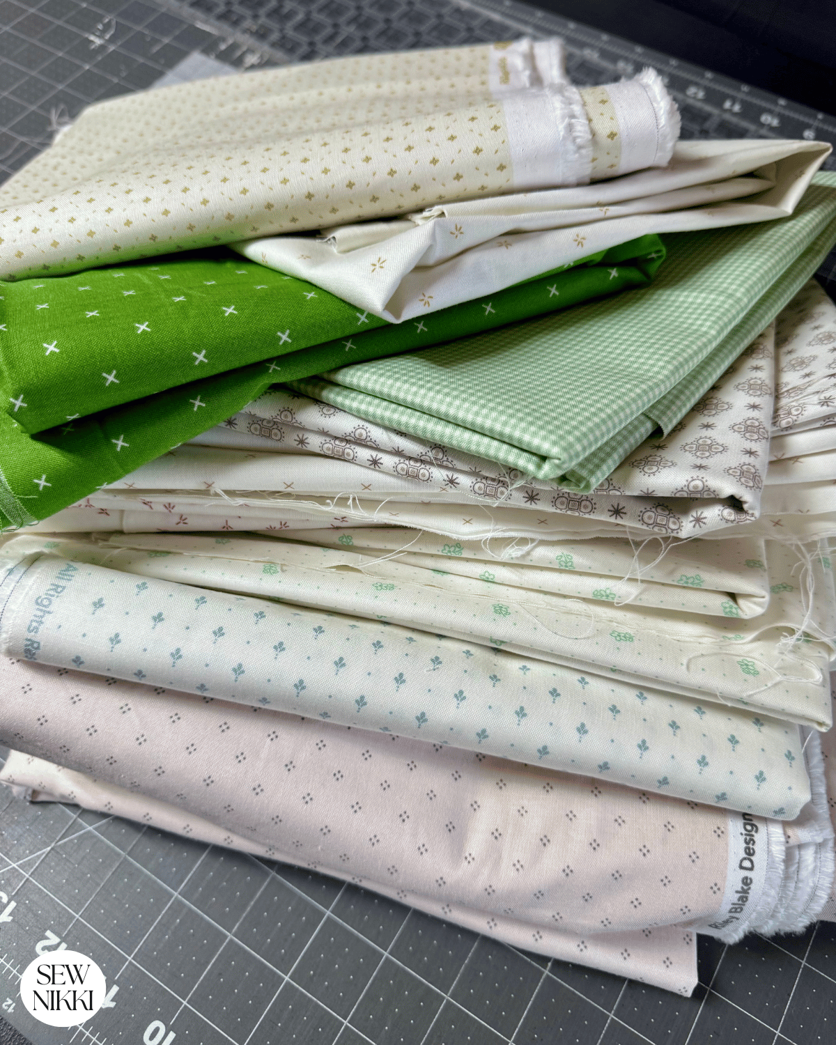 How Many Yards of Fabric Do You Need for a Quilt by Sew Nikki - a stack of fabric by the yard.