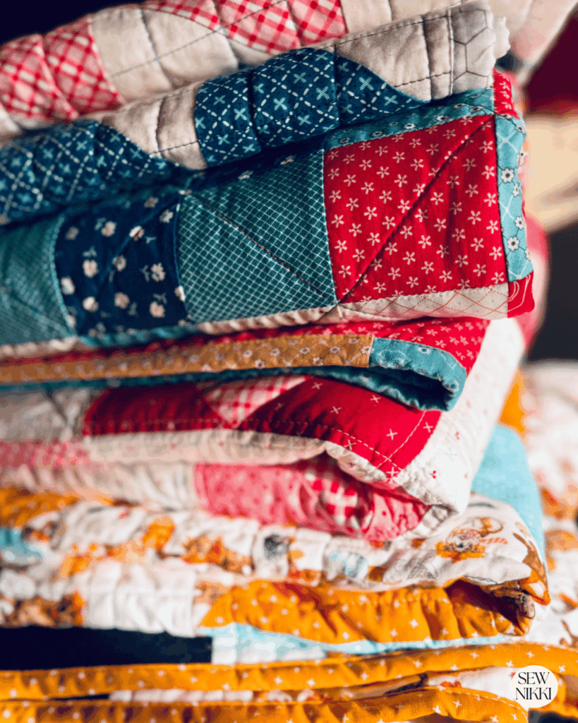 How to make a quilt look more modern - stack of quilts made by Sew Nikki