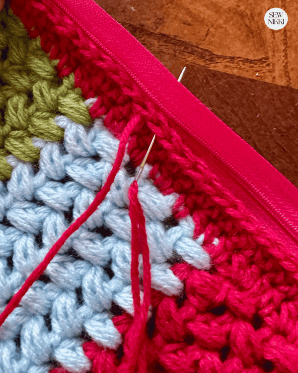 Attaching a zipper to the crochet pillow panels using a needle and yarn by Sew Nikki (1)