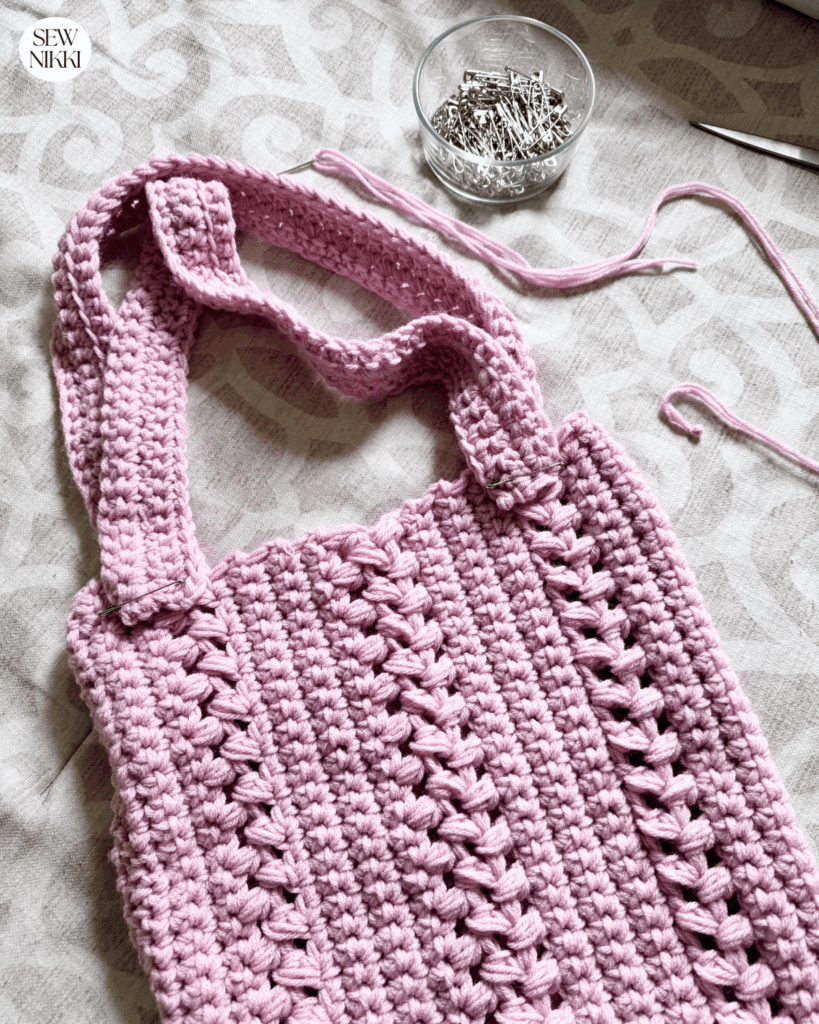 Place handle ends at least 1.5 onto bag and use safety pins to pin in place and check fit before securing with yarn needle by Sew Nikki