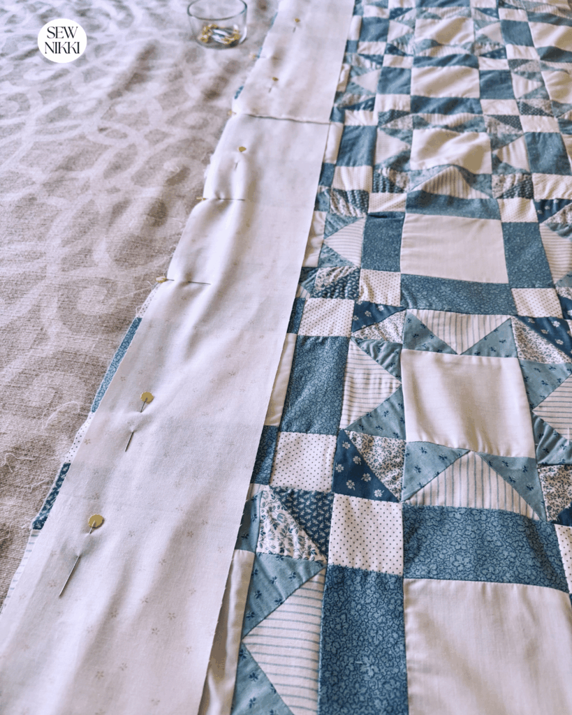 Adding the new border to my friend's imperfect first quilt top by Sew Nikki