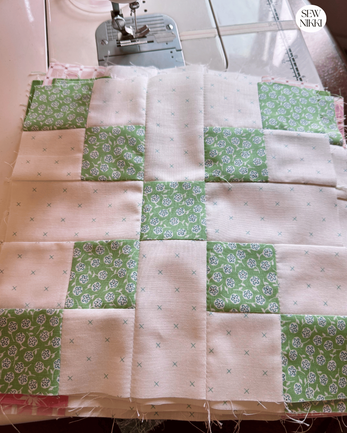 Stack of finished Irish Chain quilt blocks in scrappy fabrics by Sew Nikki