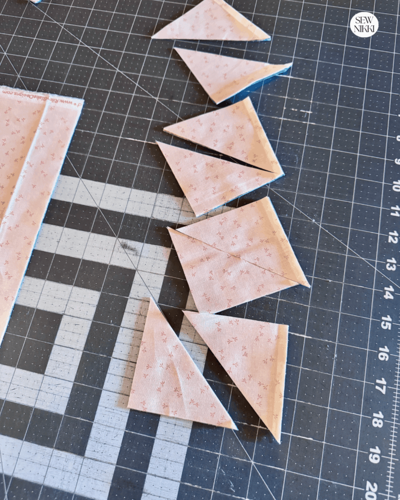 Cut a 3 strip, sub cut into four 3.5 inch squares and then cut each in half diagonally to get your triangles by Sew Nikki
