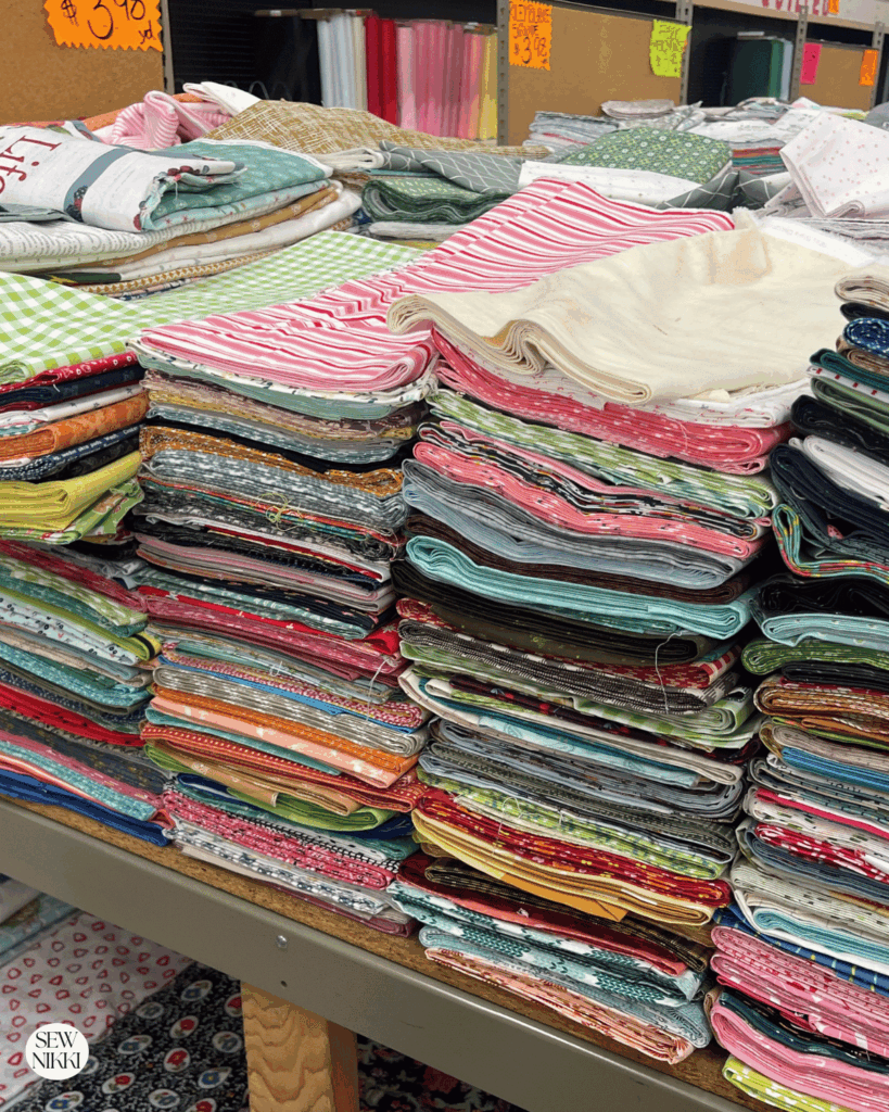 Here's a look at the off the bolt, discounted fabric racks where the price is still below five dollars a yard for name brand quilting cotton by Sew Nikki