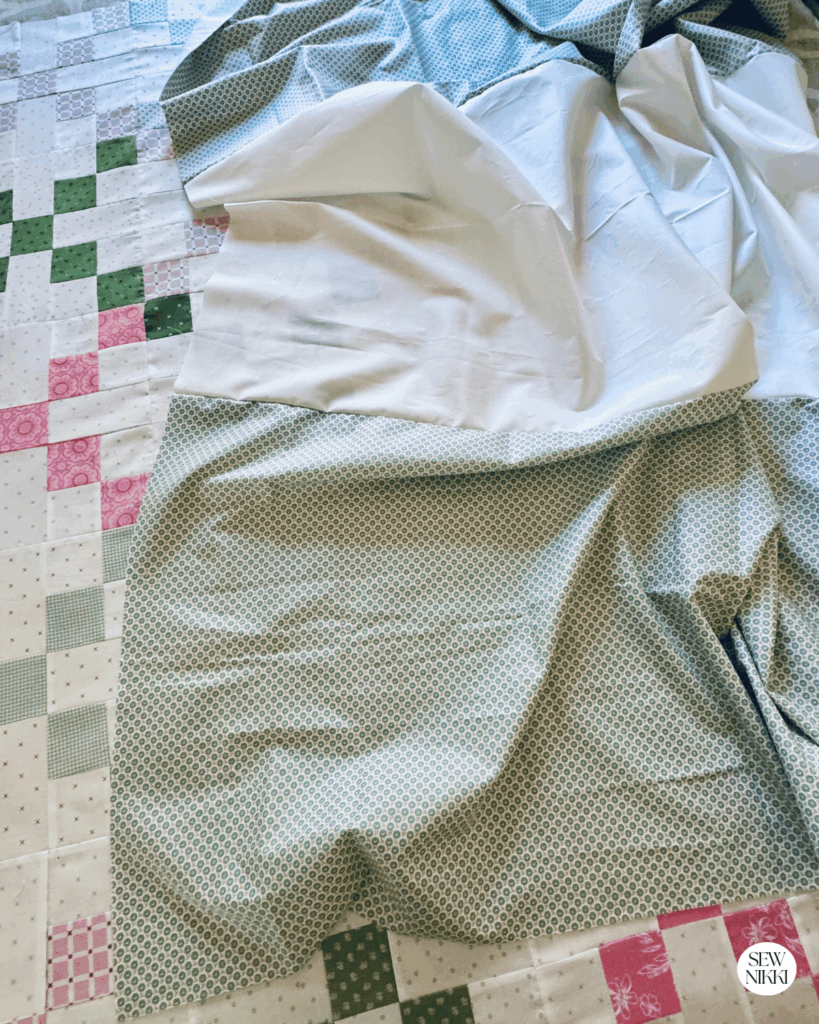 Made a scrappy quilt backing with fabric from the quilt top by Sew Nikki