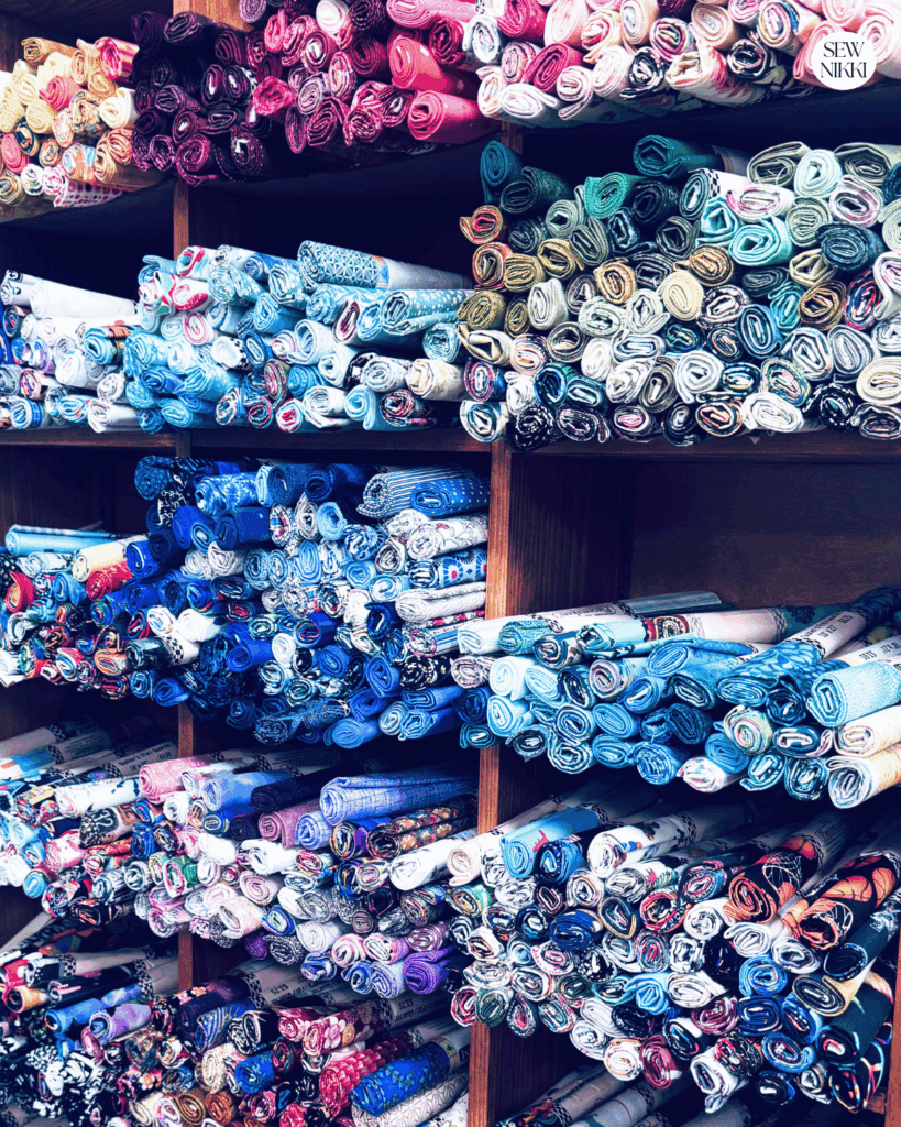 Wall full of single fat quarters for sales in all different colors at a local quilt shop by Sew Nikki