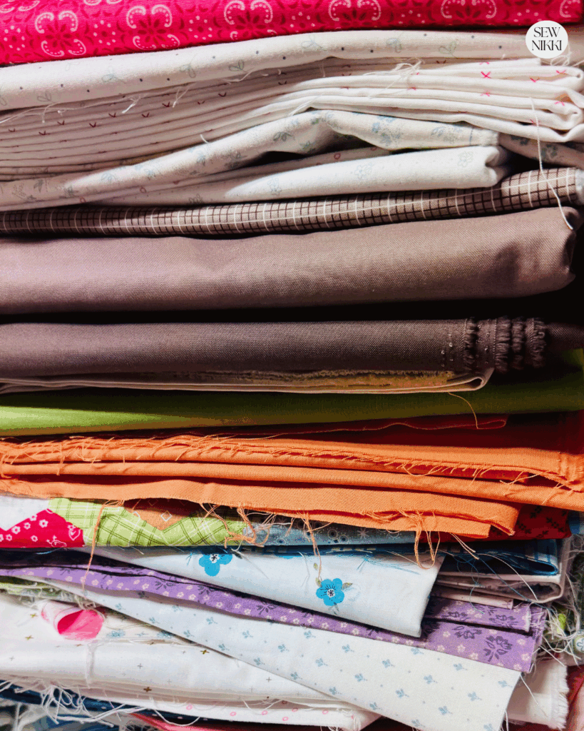 Why yardage is the best fabric for new quilters by Sew Nikki - stack of fabric yardage.