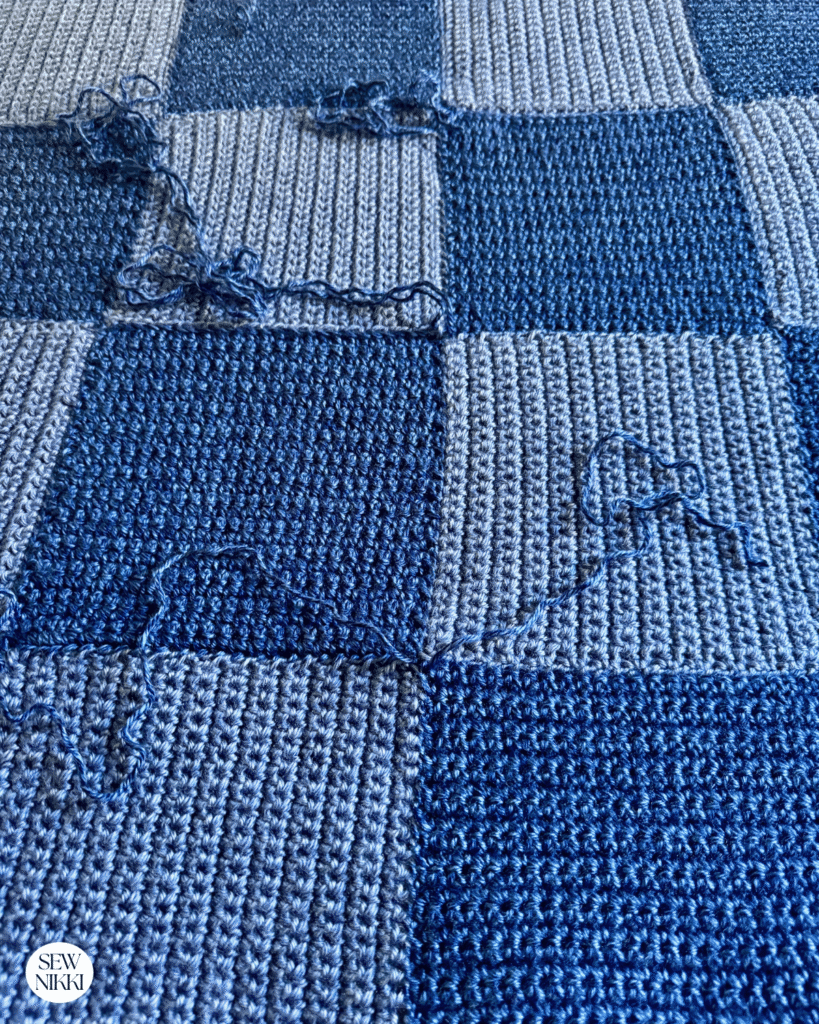 Close any gaps when you weave in the yarn tails in the square blanket crochet pattern by Sew Nikki