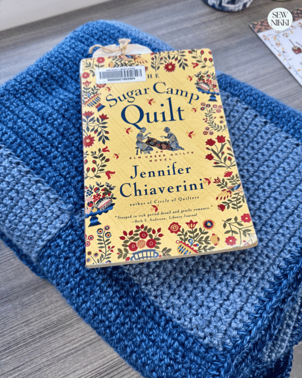 Folded squares crochet blanket under a book by Sew Nikki
